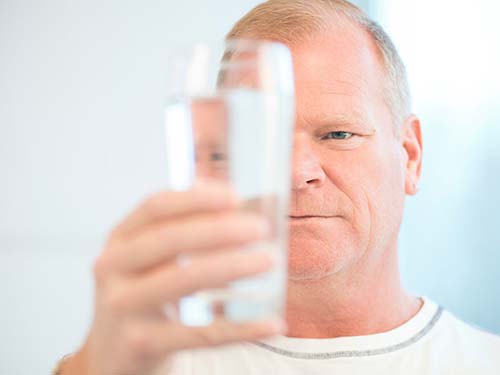 Mike Holmes holding glass of water